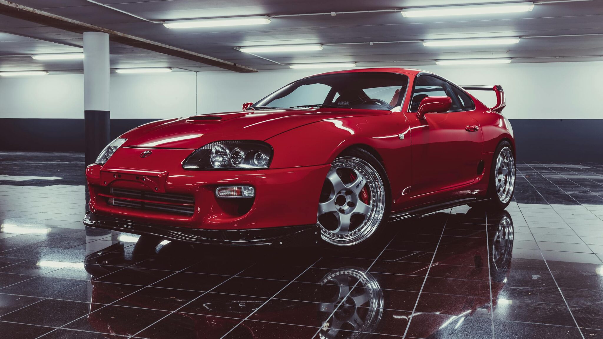 Captivating image of a shiny red sports car parked in a sleek indoor garage.
